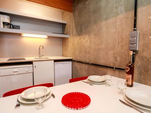 a kitchen with a table with plates and wine glasses at Studio Les Arcs 1800, 1 pièce, 5 personnes - FR-1-346-346 in Arc 1800