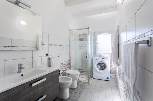 a white bathroom with a washing machine in it at Torre del mare in Menfi