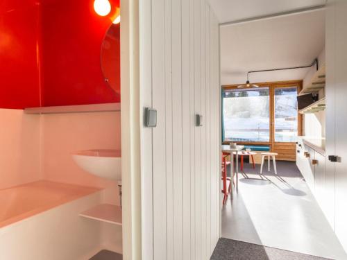 uma cozinha e sala de jantar com armários vermelhos e brancos em Studio Les Arcs 1800, 1 pièce, 5 personnes - FR-1-346-366 em Arc 1800