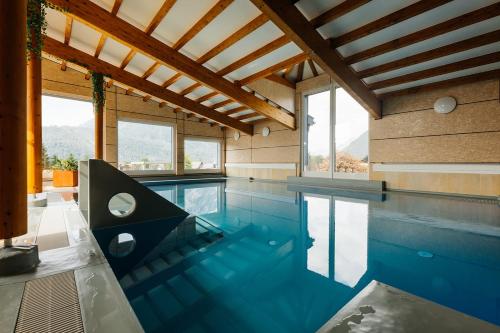 a swimming pool with blue water in a house at Appartements Gladbach in Heiterwang
