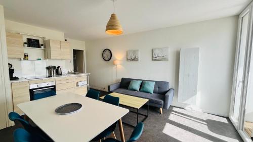 un salon avec une table et un canapé dans l'établissement Appartement des becs, convivialité marine, à Saint-Hilaire-de-Riez