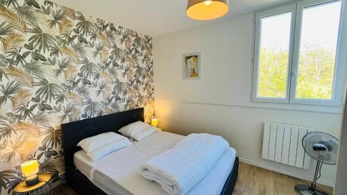 un lit dans une chambre avec un mur dans l'établissement Appartement des becs, convivialité marine, à Saint-Hilaire-de-Riez