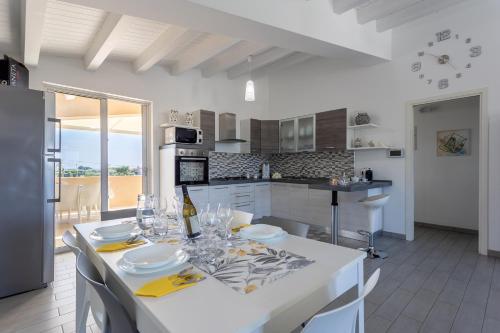 a kitchen and dining room with a white table and chairs at Torre del mare in Menfi