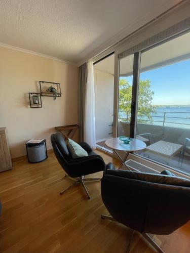 a living room with chairs and a table and a large window at Ferienwohnung GlüXX in Ulstrupfeld