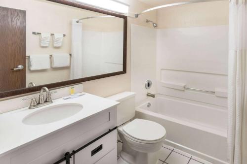 a white bathroom with a sink and a toilet at Super 8 by Wyndham Cheyenne WY in Cheyenne