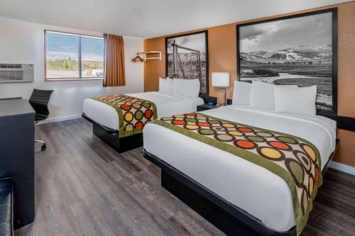 um quarto de hotel com duas camas e uma secretária em Super 8 by Wyndham Cheyenne WY em Cheyenne
