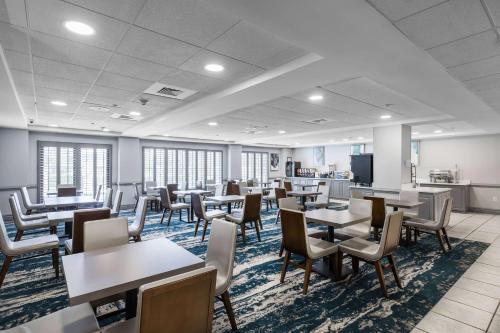 uma sala de espera vazia com mesas e cadeiras em Wingate by Wyndham Charlotte Concord Mills/Speedway em Concord