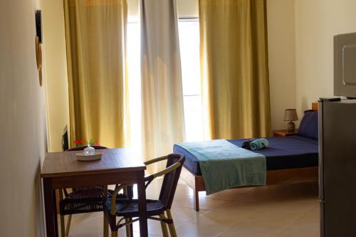 a bedroom with a bed and a table and a table and chairs at Beauty Plaza Suites in Santa Maria