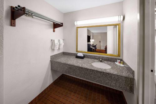 La salle de bains est pourvue d'un lavabo et d'un miroir. dans l'établissement Super 8 by Wyndham Baton Rouge/I-10, à Bâton-Rouge