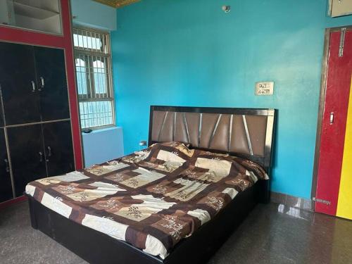 Cama en habitación con pared azul en Stunning 4-Bedroom Family Haven en Patna