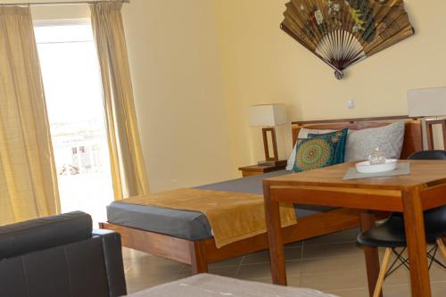 a bedroom with a bed and a table and a desk at Beauty Plaza Suites in Santa Maria