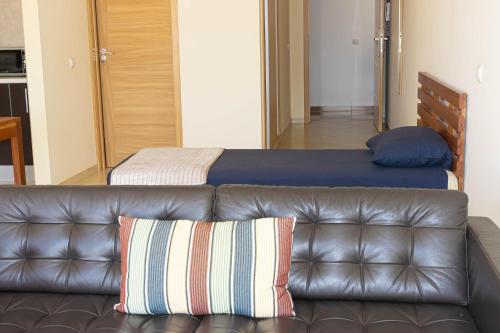 a leather couch in a room with a bed at Beauty Plaza Suites in Santa Maria