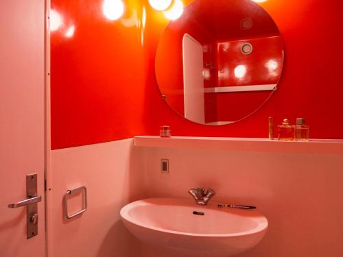 ein rotes Badezimmer mit einem Waschbecken und einem Spiegel in der Unterkunft Studio Les Arcs 1800, 1 pièce, 4 personnes - FR-1-346-464 in Arc 1800