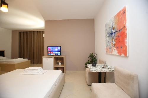 um quarto branco com uma cama e uma televisão em TekB Rooms & Apartments em Vlorë