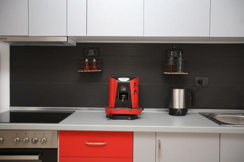 a red coffee maker sitting on top of a kitchen counter at TekB Rooms & Apartments in Vlorë