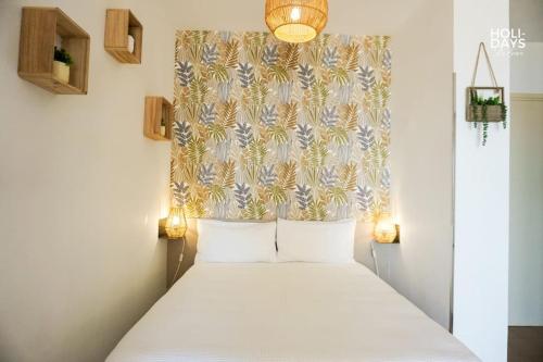 - une chambre avec un lit blanc et une tête de lit fleurie dans l'établissement Brisa Marina Apartamento, à Empuriabrava