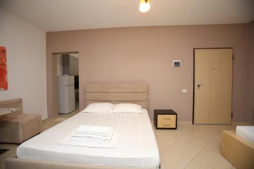 a bedroom with a large bed with white sheets at TekB Rooms & Apartments in Vlorë