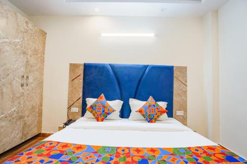a bedroom with a large bed with colorful pillows at FabHotel The Luxe Inn in New Delhi