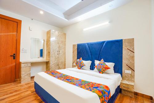 a bedroom with a large bed with a blue headboard at FabHotel The Luxe Inn in New Delhi