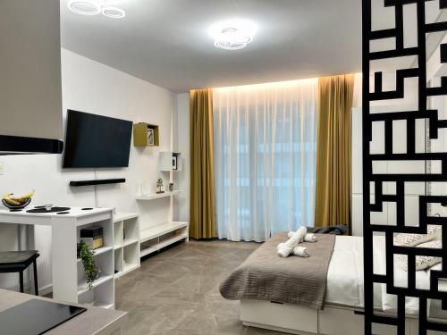 a bedroom with a bed and a tv and a desk at Studio 147 Mamaia Nord in Mamaia