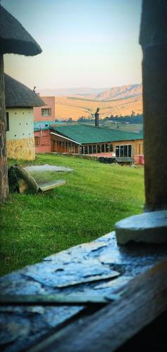 a view of a building with a field of grass at Sobantu Guest Farm in Piggs Peak