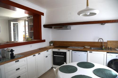 une cuisine avec un comptoir blanc et une table dans l'établissement Gure Oroitza, à Hendaye