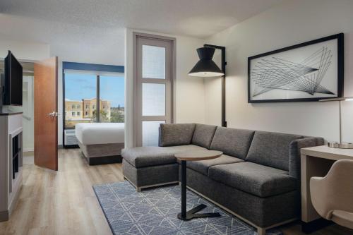 ein Wohnzimmer mit einem Sofa und einem Bett in der Unterkunft Hyatt Place Sacramento Rancho Cordova in Rancho Cordova