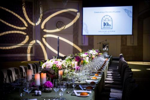 a long table in a room with candles and flowers at Waldorf Astoria Jerusalem in Jerusalem