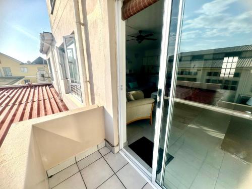 a sliding glass door on a balcony with a couch at Haus Helios Eight Central in Swakopmund