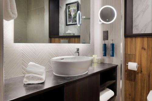 a bathroom with a large white sink and a mirror at Doubletree by Hilton Belfast Templepatrick in Templepatrick