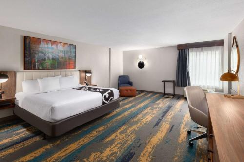 a hotel room with a bed and a desk at La Quinta by Wyndham Knoxville Central Papermill in Knoxville