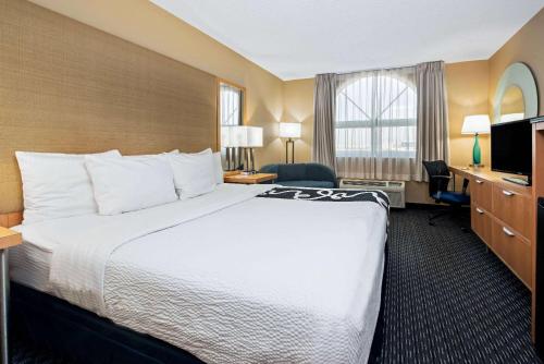 a hotel room with a large bed and a television at La Quinta by Wyndham West Palm Beach Airport in West Palm Beach