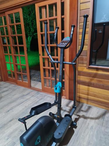 an exercise bike parked next to a building at Chalé Tucano Recanto Buscapé SFX in São Francisco Xavier