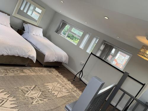 a bedroom with two beds and a desk and windows at Adanhouse-stockland spacious 5 bedroom house sleeps 12 private garden in Cardiff