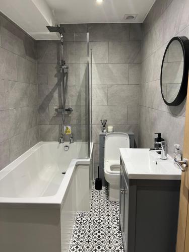 een badkamer met een bad, een toilet en een wastafel bij The Grange in Birkenhead