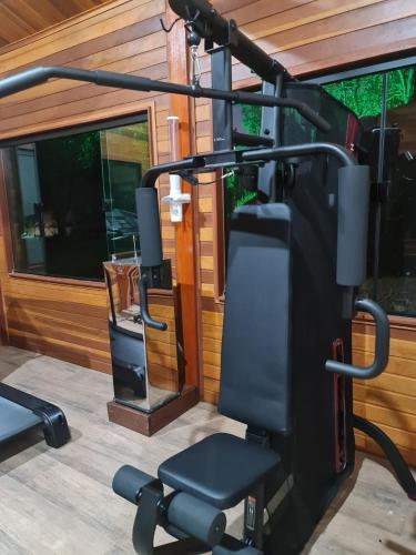 a gym with a bench and a simulator at Chalé Tucano Recanto Buscapé SFX in São Francisco Xavier