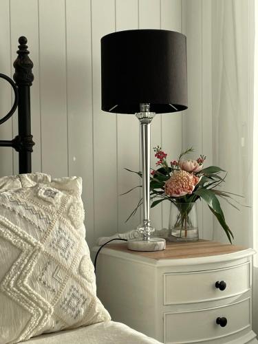 a lamp on a night stand next to a bed at Vineyard Views Rutherglen in Rutherglen