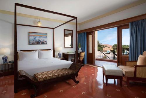 a bedroom with a large bed and a balcony at Radisson Blu Resort, Goa in Cavelossim