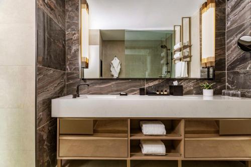 uma casa de banho com um lavatório e um espelho em Thompson Central Park New York, by Hyatt em Nova York