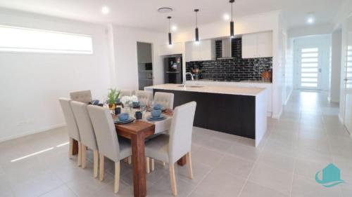 uma cozinha e sala de jantar com uma mesa de madeira e cadeiras em Surfers Paradise em Catherine Hill Bay