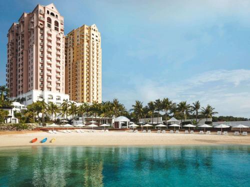 - une vue sur une plage avec deux grands bâtiments dans l'établissement Mövenpick Hotel Mactan Island Cebu, à Mactan