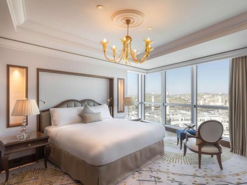 a bedroom with a bed and a large window at Raffles Makkah Palace in Makkah