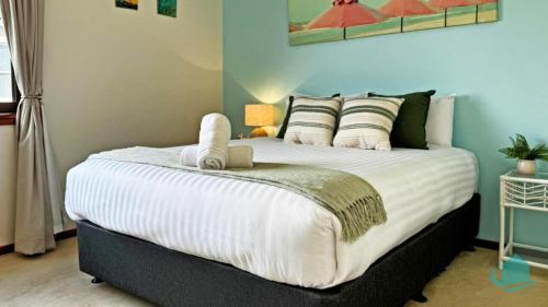 a bedroom with a large bed with white sheets at Village Bay Lake house family Lake House with Spa in Marks Point