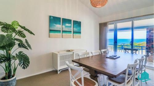 a dining room with a table and chairs at Oceanview Beach House in Caves Beach