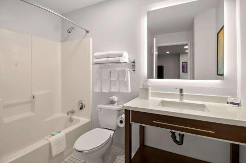 ミッドベールにあるMainStay Suites Salt Lake City Fort Unionの白いバスルーム(トイレ、シンク付)