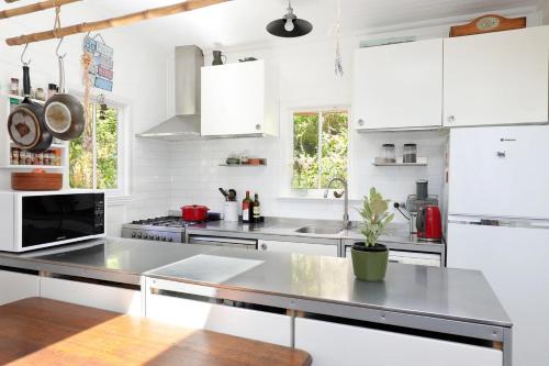 a kitchen with white cabinets and a stainless steel counter top at Blue Mountains Bliss Cottages Katoomba - Rosebud in Katoomba