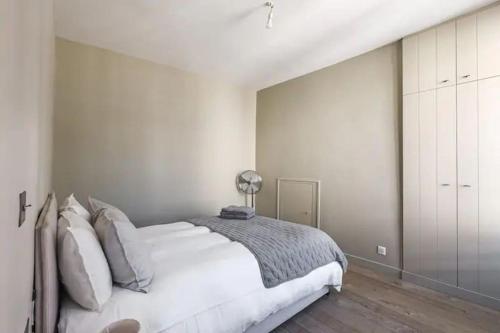 - une chambre blanche avec un grand lit et une lampe dans l'établissement Elegant apartment in the heart of the Marais 60m2, à Paris