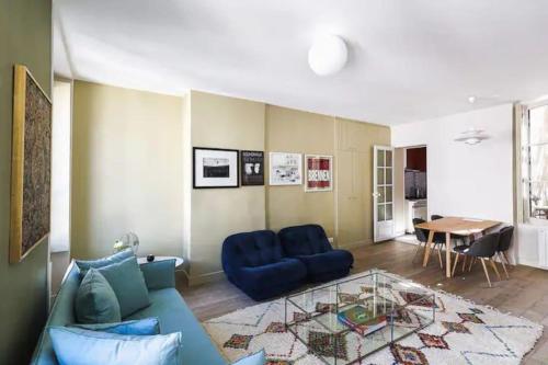 un salon avec un canapé bleu et une table dans l'établissement Elegant apartment in the heart of the Marais 60m2, à Paris