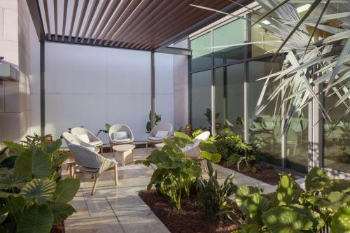 オーランドにあるConrad Orlandoの建物内の椅子と植物が置かれたロビー
