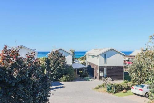 a row of houses with the ocean in the background at Haven at Caves in Caves Beach